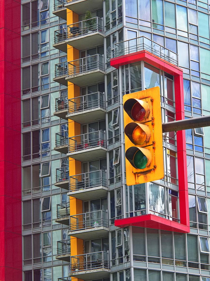 Yellow Traffic Light Against Modern Colorful Apartment Building