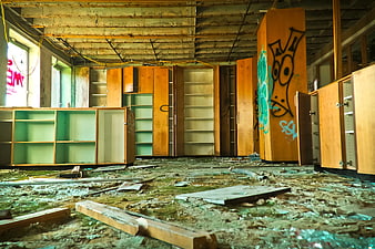 Abandoned Room with Graffiti on Wooden Cabinets and Debris