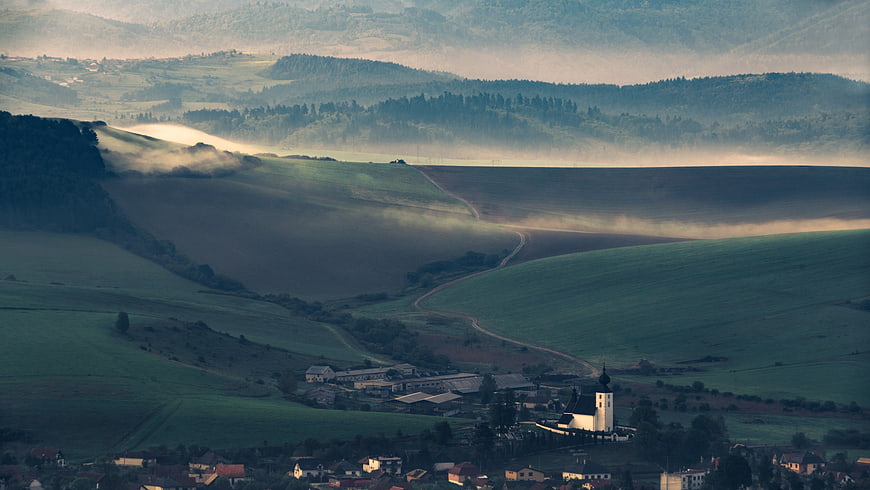 Misty Morning Landscape with Rolling Hills and Village Church
