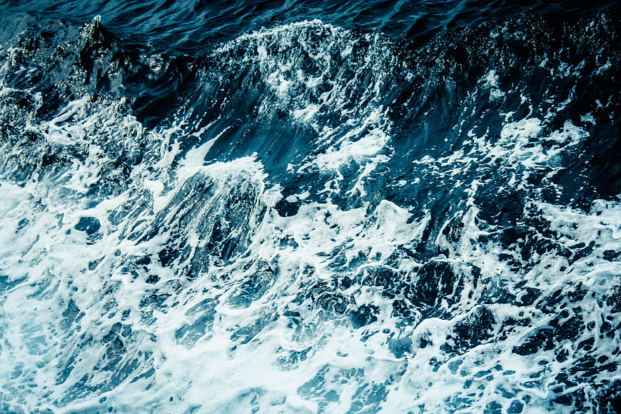 Aerial View of Turbulent Blue Ocean Waves and White Sea Foam