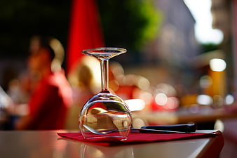 Upside down wine glass on red napkin at outdoor restaurant