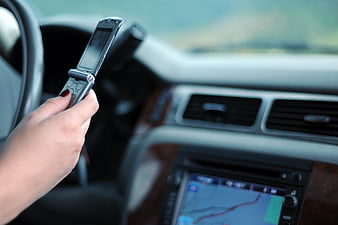 Woman Using Flip Phone While Driving Car Interior