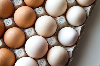 Top view of brown and white eggs in a carton