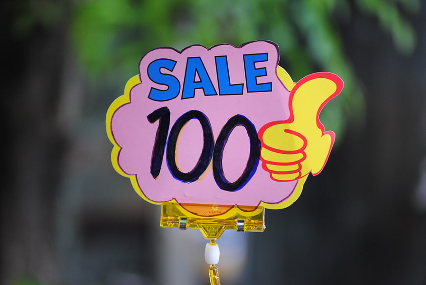 Hand-painted pink sale sign with 100 discount and thumbs up