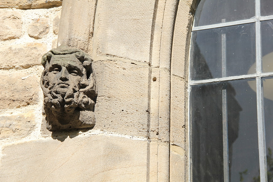 Ancient stone face sculpture on historic church wall