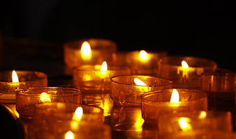 Glowing tea light candles in a dark room