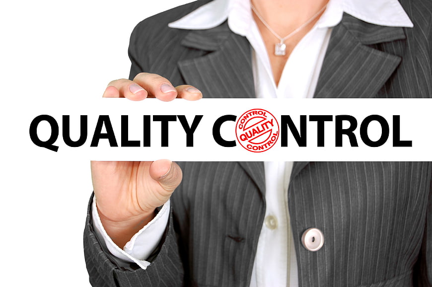 Businesswoman holding quality control sign with stamp