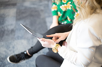Two women collaborating on a tablet in a casual office setting