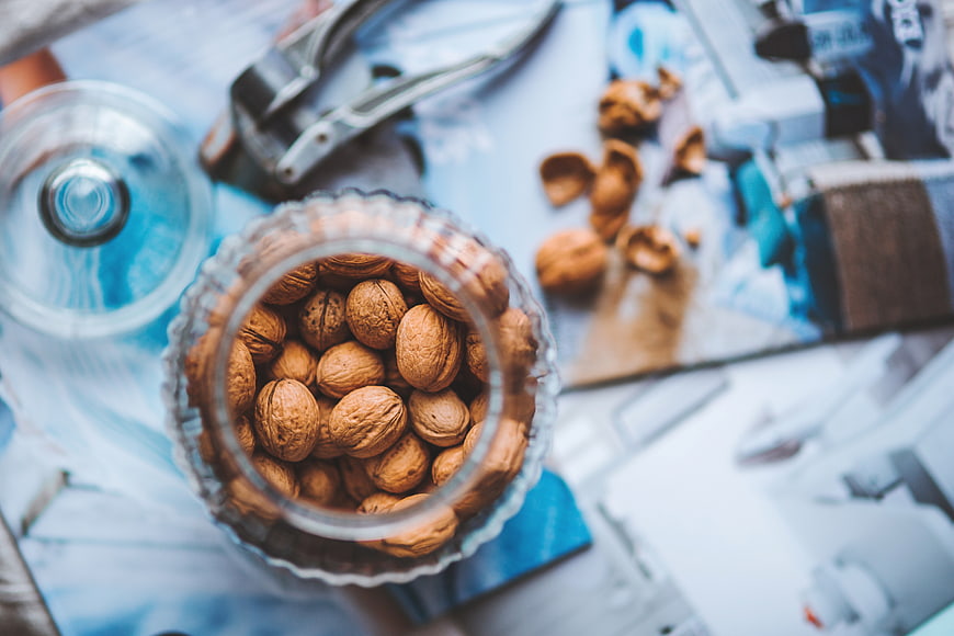 Top View of Walnuts in Glass Jar with Cracker