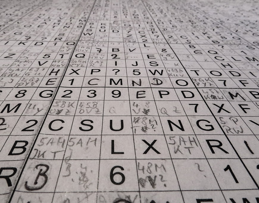 Close-up of a handwritten alphanumeric grid puzzle on paper
