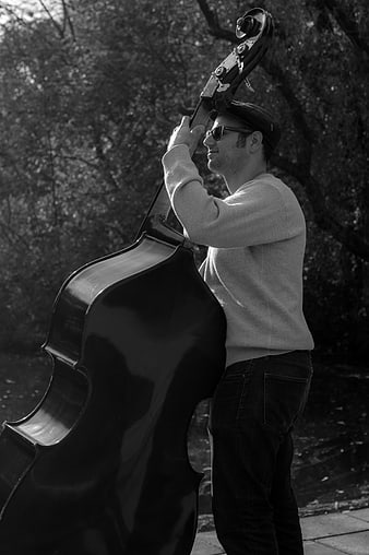 Man holding double bass in black and white