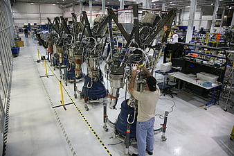 Engineer assembling rocket engines in aerospace manufacturing facility