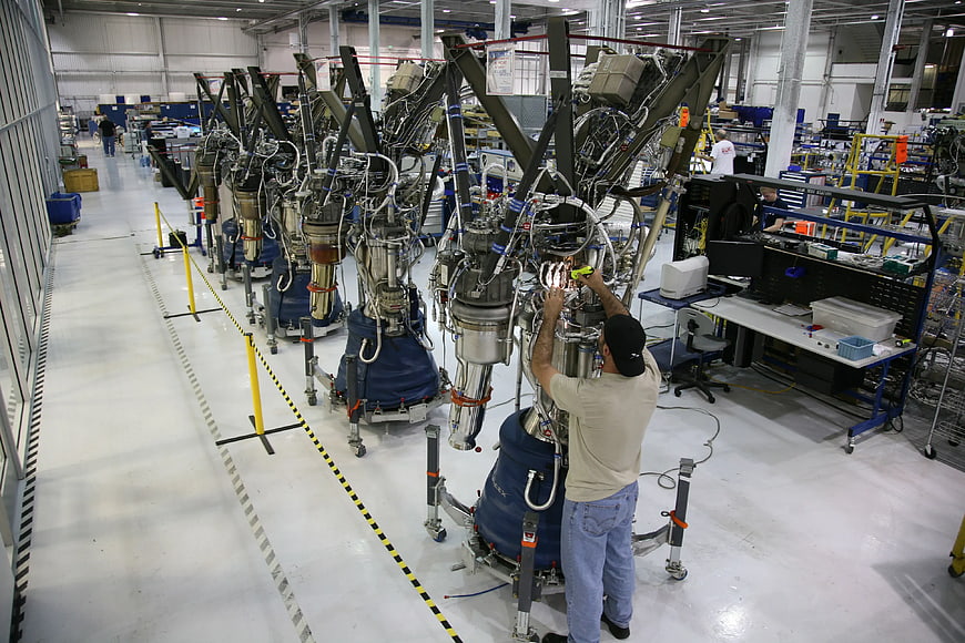 Engineer assembling rocket engines in aerospace manufacturing facility