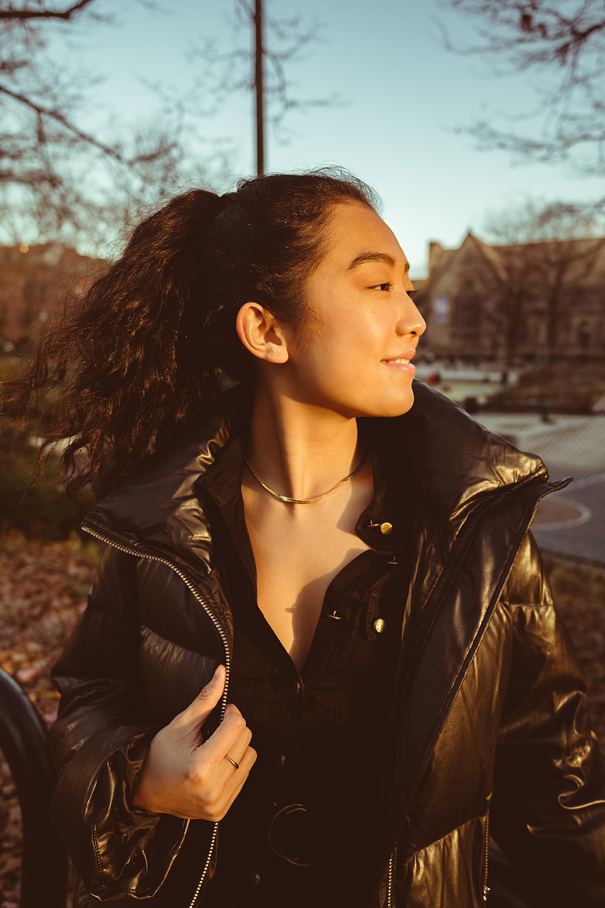 Asian Woman in Black Jacket Smiling in Golden Hour Sunlight
