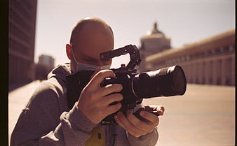 Filmmaker Shooting Video with Cinema Camera in City Square