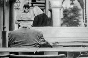 Senior man in hat sitting alone in church pew