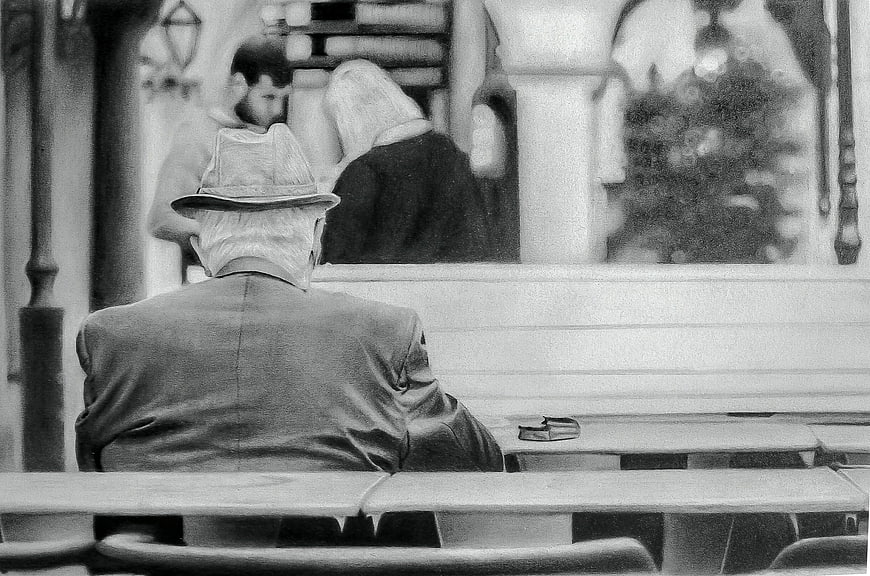 Senior man in hat sitting alone in church pew