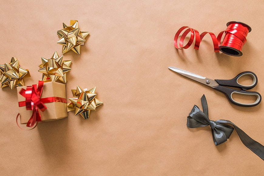 Christmas gift wrapping supplies on kraft paper background