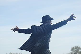 Man in Pinstripe Suit and Bowler Hat with Arms Outstretched