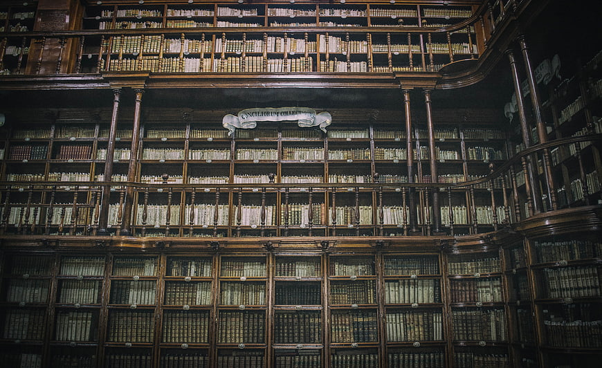 Historic Library Interior With Antique Books And Wooden Shelves