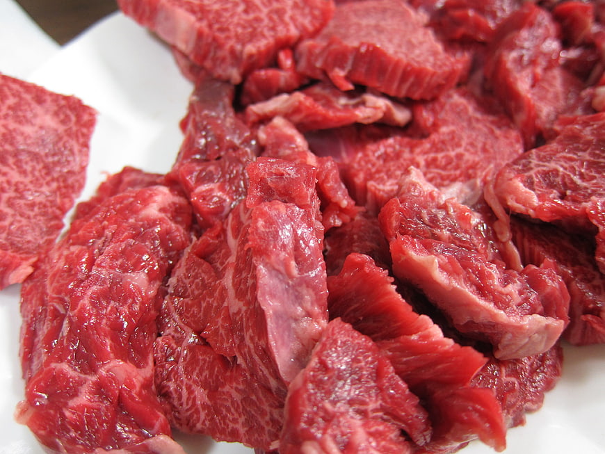 Close-up of raw marbled beef sirloin chunks on white plate