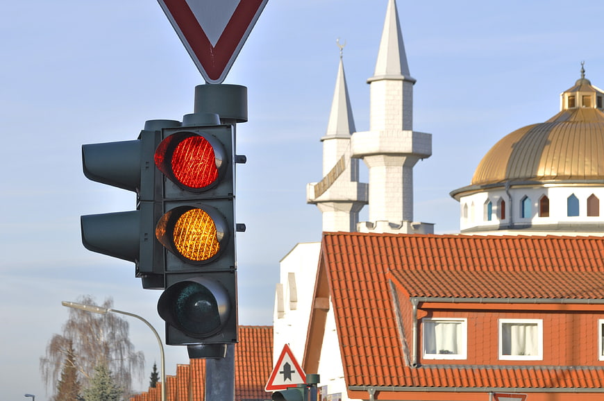 Red and yellow traffic lights with mosque minarets in background