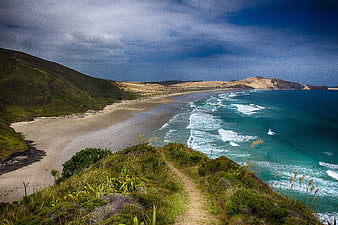 Scenic coastal path overlooking sandy beach and turquoise ocean waves
