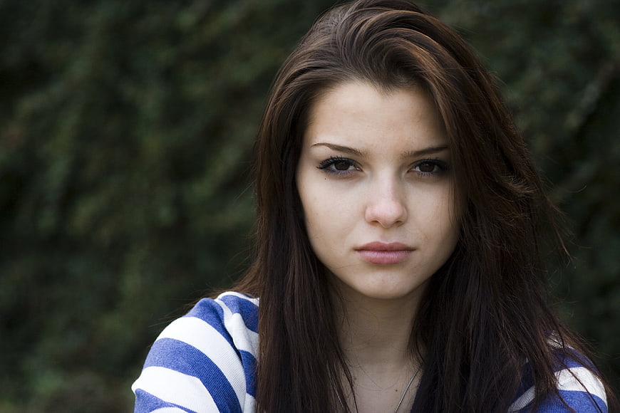 Portrait of young brunette woman in striped shirt