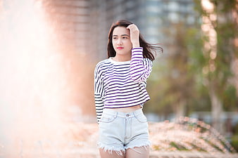 Young Woman in Striped Top and Denim Shorts Outdoors