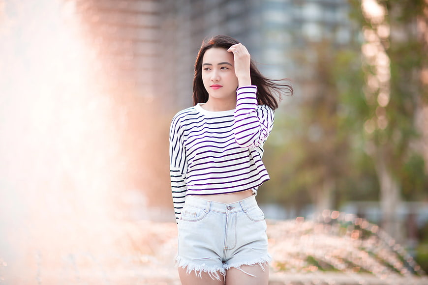 Young Woman in Striped Top and Denim Shorts Outdoors