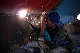 Welder Working on Metal Structure with Sparks Flying