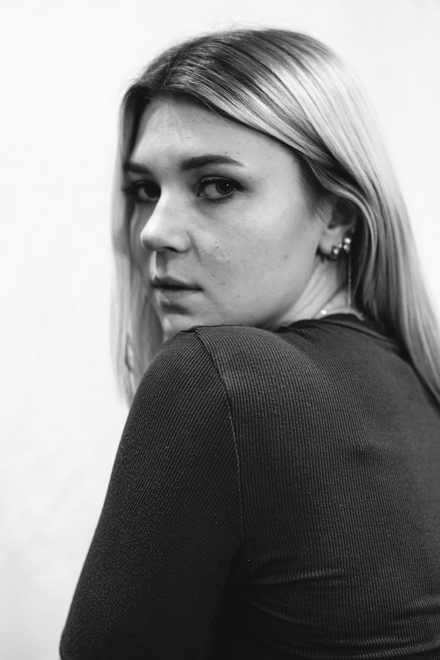 Black and white portrait of young woman looking over shoulder