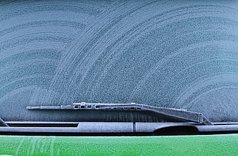 Frosty Car Windshield with Wiper Blades in Winter