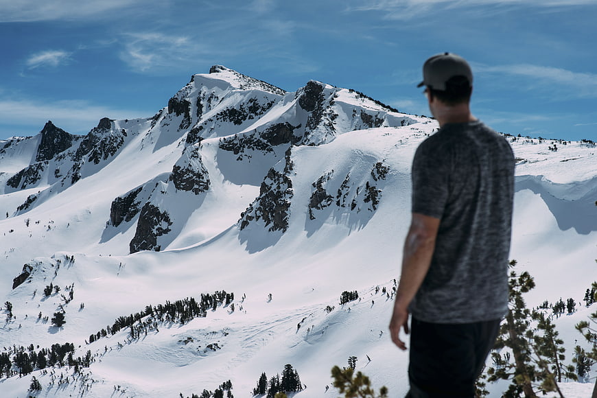 Man Looking at Snowy Mountain Peak in Winter
