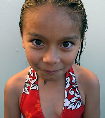 Close-up portrait of a smiling young girl with wet hair