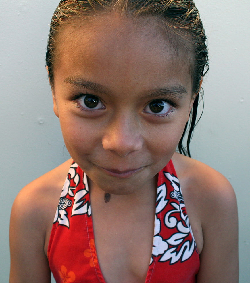 Close-up portrait of a smiling young girl with wet hair