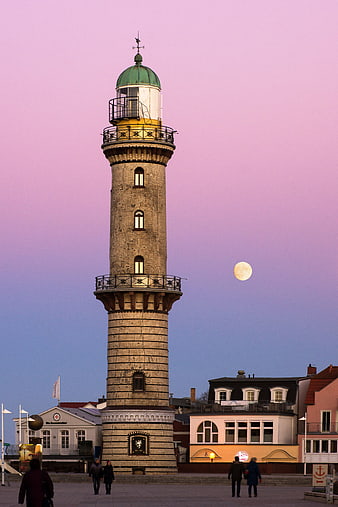 Historic Lighthouse in Warnemünde with Full Moon at Dusk