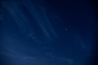 Deep Blue Night Sky with Faint Stars and Wispy Clouds