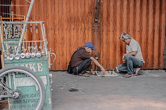 Two elderly men playing chess on the street