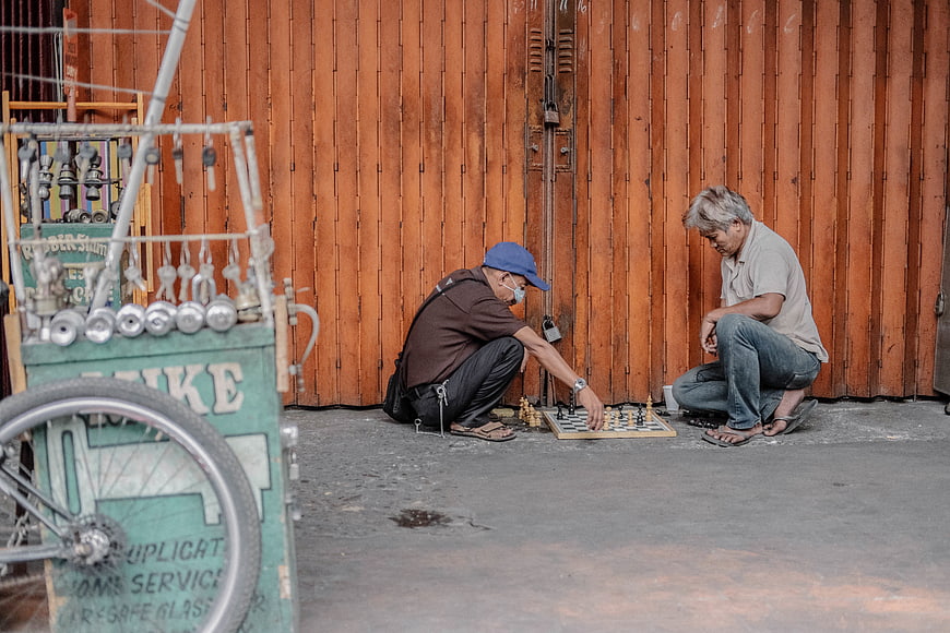 Two elderly men playing chess on the street