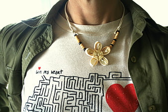 Close-up of handmade cowrie shell flower necklace on graphic tee