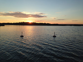Serene Sunset Over Calm Water with Buoys