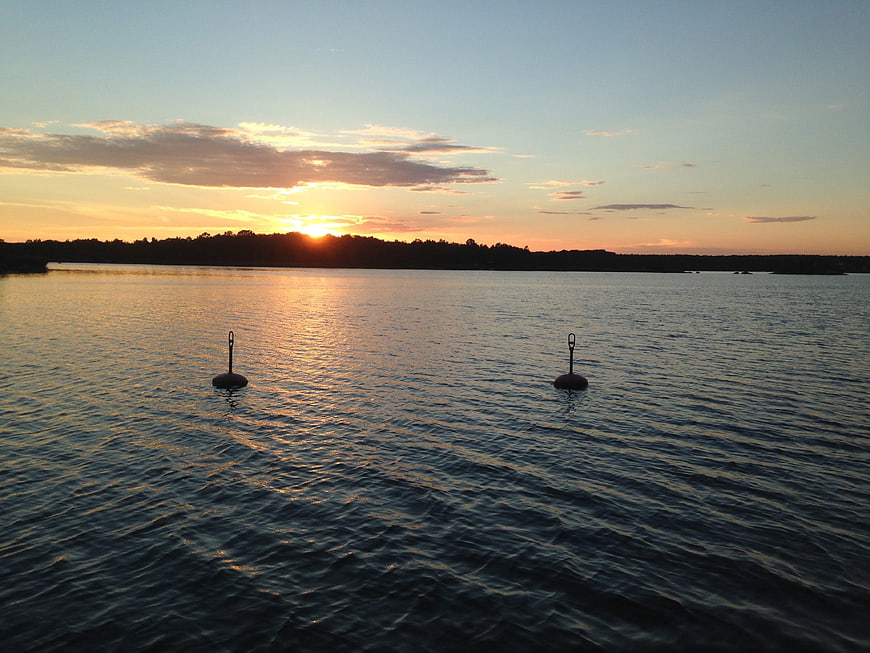 Serene Sunset Over Calm Water with Buoys