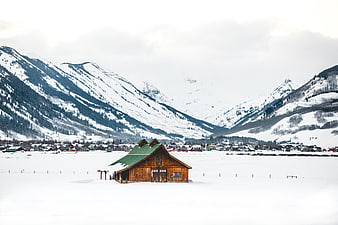 Rustic wooden barn in snowy mountain valley winter landscape