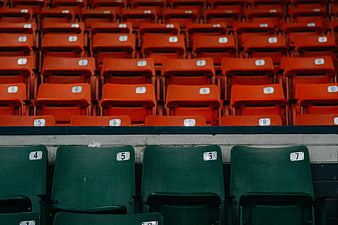 Empty stadium seats with green and orange rows