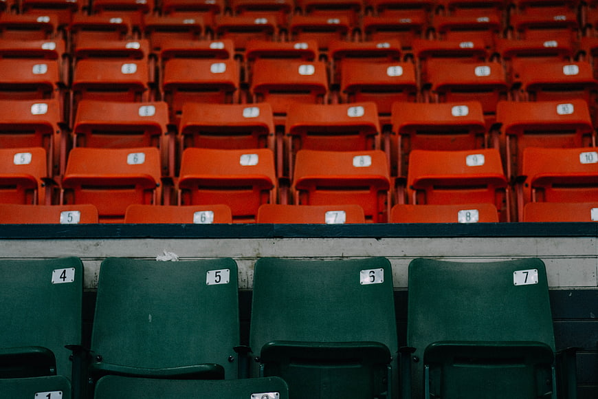 Empty stadium seats with green and orange rows