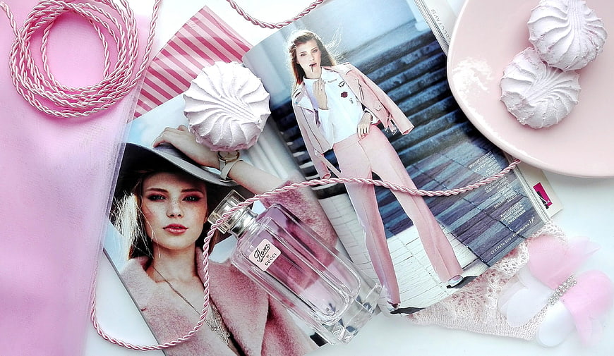 Pink perfume bottle flat lay with meringue cookies and fashion magazine