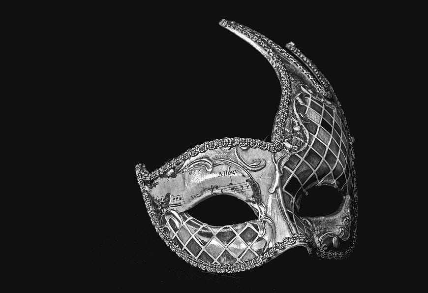 Silver Venetian carnival mask with musical notes on black background