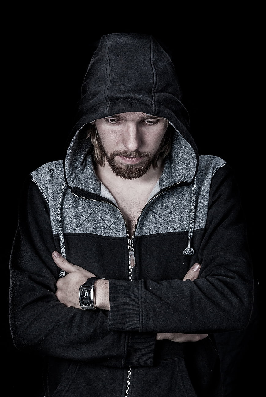 Portrait of a man in a black hoodie with crossed arms