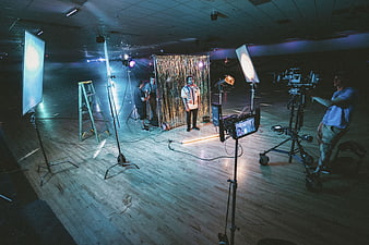 Film crew shooting video in studio with lights and camera